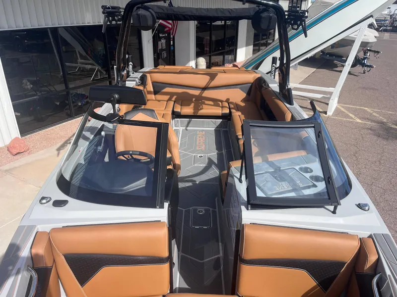 Slide: The Image of 2025 Supreme S240 boat interior with tan leather seats and modern dashboard. - 10