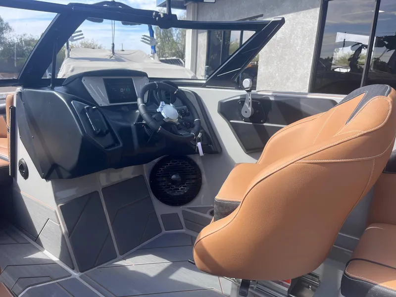 Slide: The Image of Interior of 2025 Supreme S240 boat with modern dashboard and tan seating. - 7