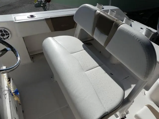 Slide: The Image of 2023 Robalo R200 boat interior with white cushioned seating and steering wheel. - 12