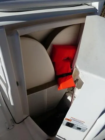Slide: The Image of 2023 Robalo R200 boat storage compartment with life jacket. - 19