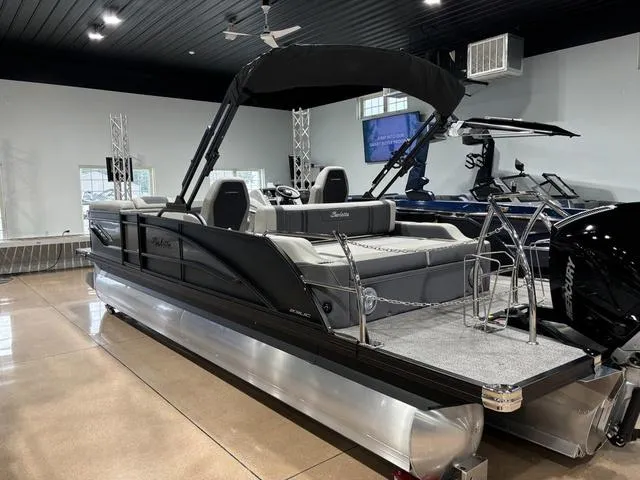Slide: The Image of 2025 Barletta Corsa 23UC pontoon boat in showroom, sleek design, black canopy, modern interior. - 7