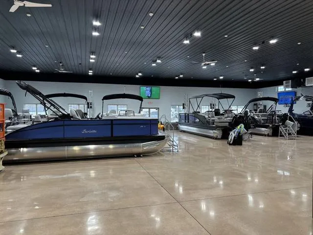 Slide: The Image of 2025 Barletta Corsa 23UC pontoon boats displayed in a spacious showroom. - 8