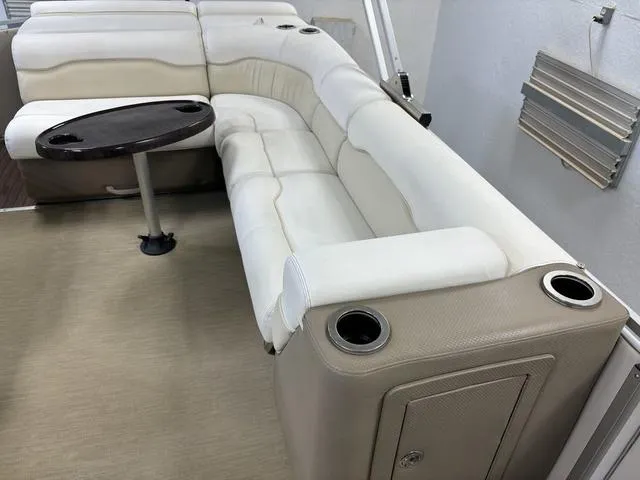 Slide: The Image of Luxurious seating on a 2013 Harris ROYAL 250 pontoon boat with a round table and cup holders. - 22