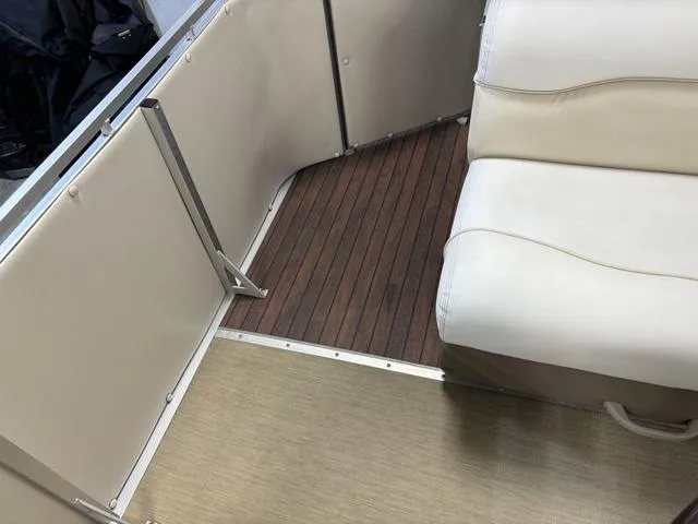 Slide: The Image of Interior of a 2013 Harris ROYAL 250 boat with beige seating and wood flooring. - 24