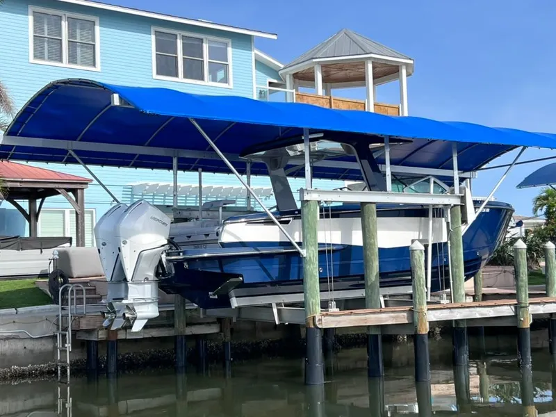 Slide: The Image of 2022 Aviara AV 32 Outboard with Joystick docked under blue canopy. - 11