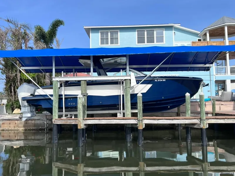 Slide: The Image of 2022 Aviara AV 32 Outboard with Joystick docked under blue canopy. - 12