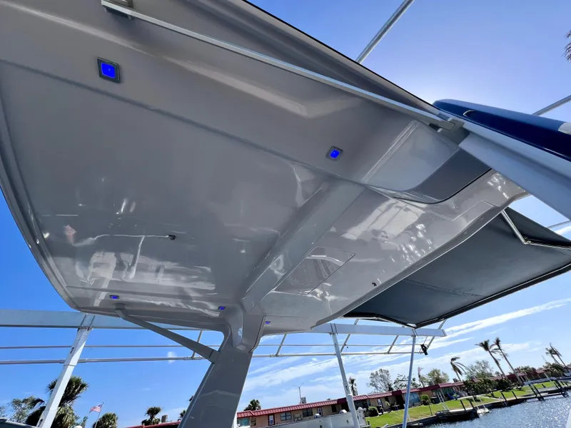 Slide: The Image of Aviara AV 32 Outboard 2022 boat canopy with blue LED lights, clear sky background. - 23