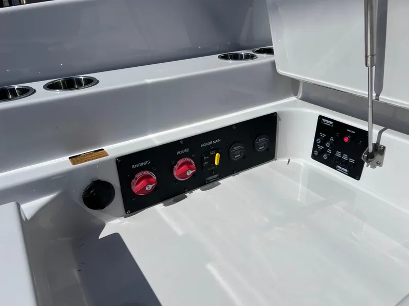 Slide: The Image of Control panel of 2022 Aviara AV 32 Outboard boat, featuring engine switches and cup holders. - 28