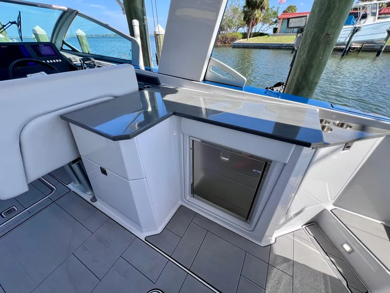 Slide: The Image of 2022 Aviara AV 32 Outboard boat interior with sleek kitchenette and waterfront view. - 35