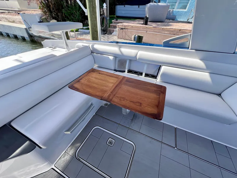 Slide: The Image of 2022 Aviara AV 32 Outboard boat interior with sleek seating and wooden table. - 40