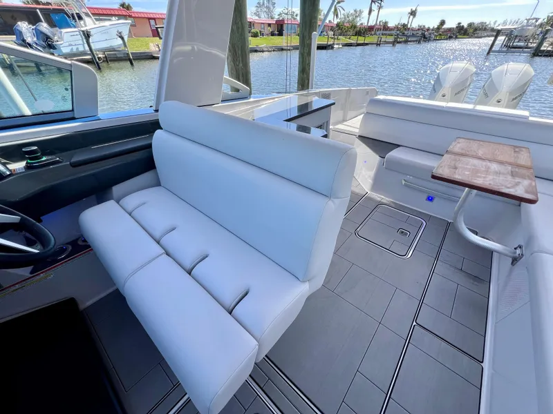 Slide: The Image of 2022 Aviara AV 32 Outboard boat interior with white seating and wooden table. - 45