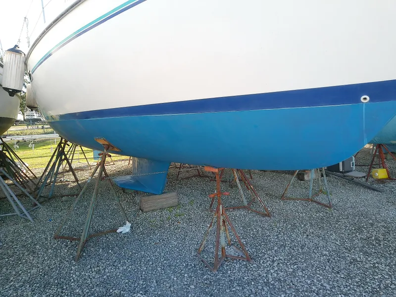 Slide: The Image of Catalina 36 MkII 1995 sailboat on stands, hull view, gravel ground. - 2