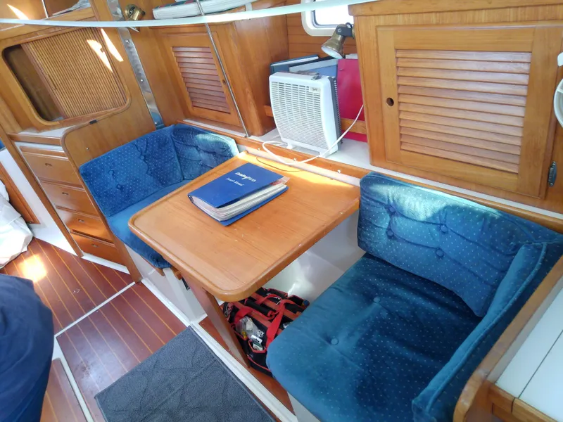 Slide: The Image of Cozy interior of 1995 Catalina 36 MkII sailboat with blue seating and wooden table. - 32