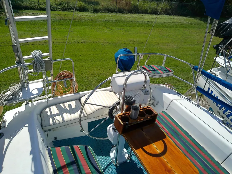 Slide: The Image of 1995 Catalina 36 MkII sailboat cockpit with striped seating and wooden table. - 8
