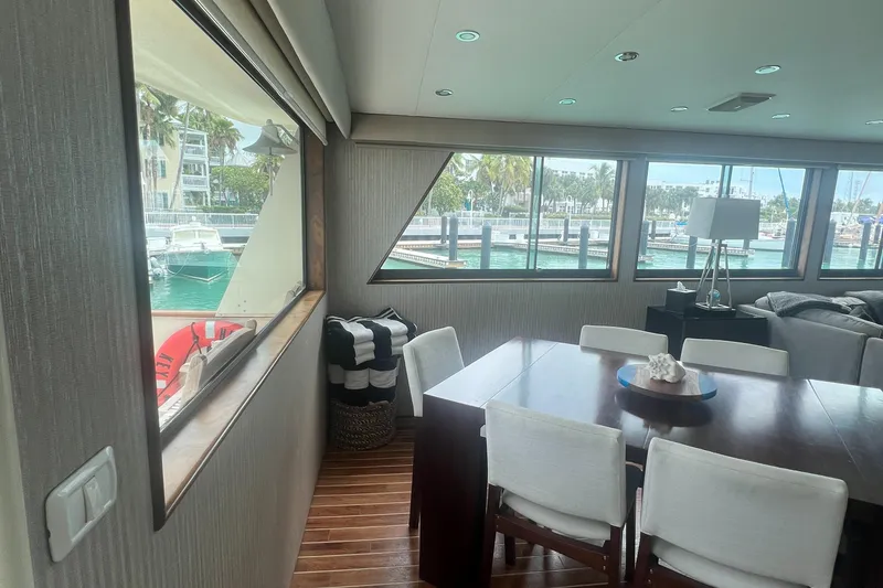 Slide: The Image of Interior of 1990 Hatteras 70 Cockpit Motor Yacht with dining area and marina view. - 11