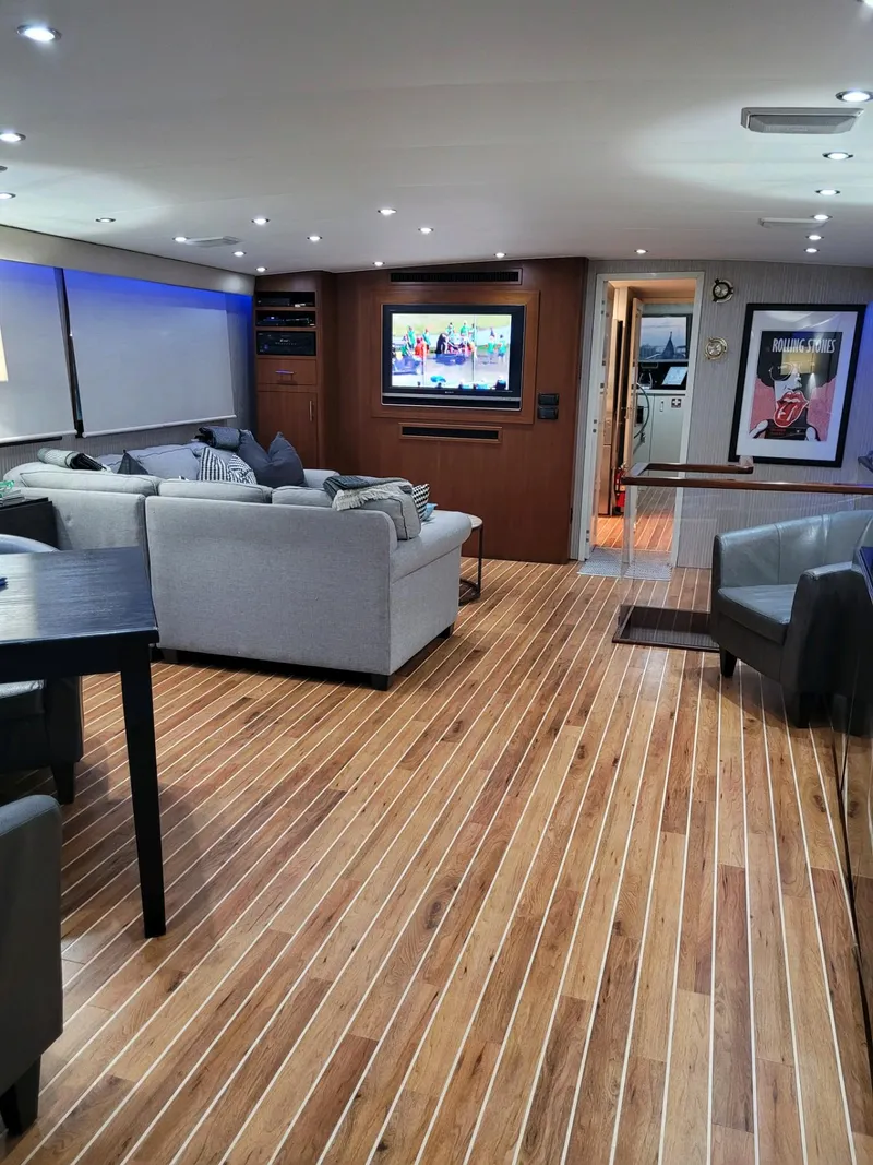 Slide: The Image of Luxurious interior of 1990 Hatteras 70 Cockpit Motor Yacht with modern furnishings and wood flooring. - 12