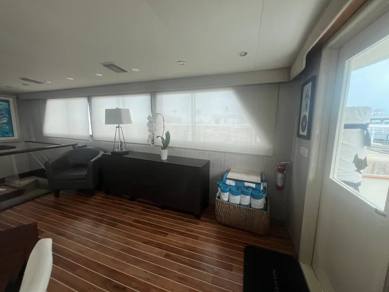 Slide: The Image of Interior of 1990 Hatteras 70 Cockpit Motor Yacht with wooden flooring and modern decor. - 17