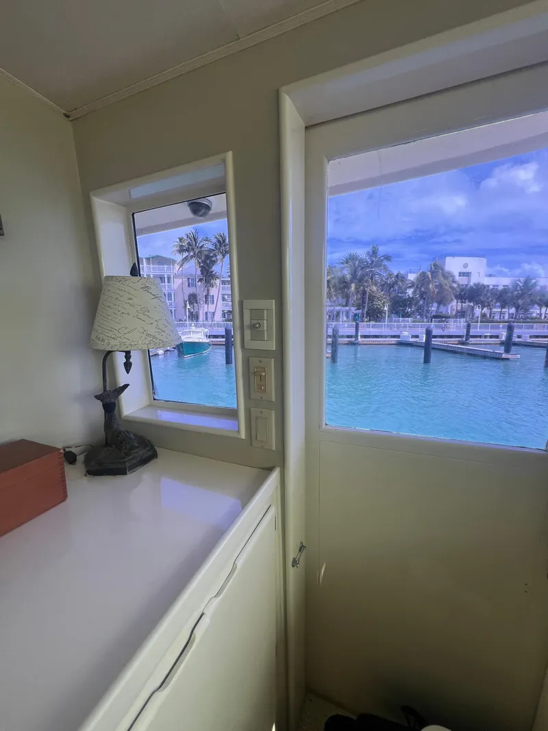 Slide: The Image of Interior view from 1990 Hatteras 70 Cockpit Motor Yacht, showcasing marina through windows. - 18