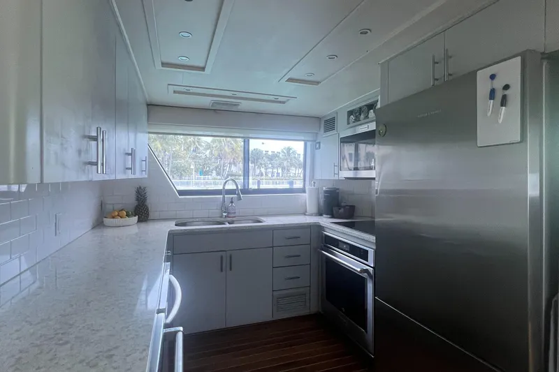Slide: The Image of Modern kitchen interior on 1990 Hatteras 70 Cockpit Motor Yacht, featuring sleek appliances and ample counter space. - 19