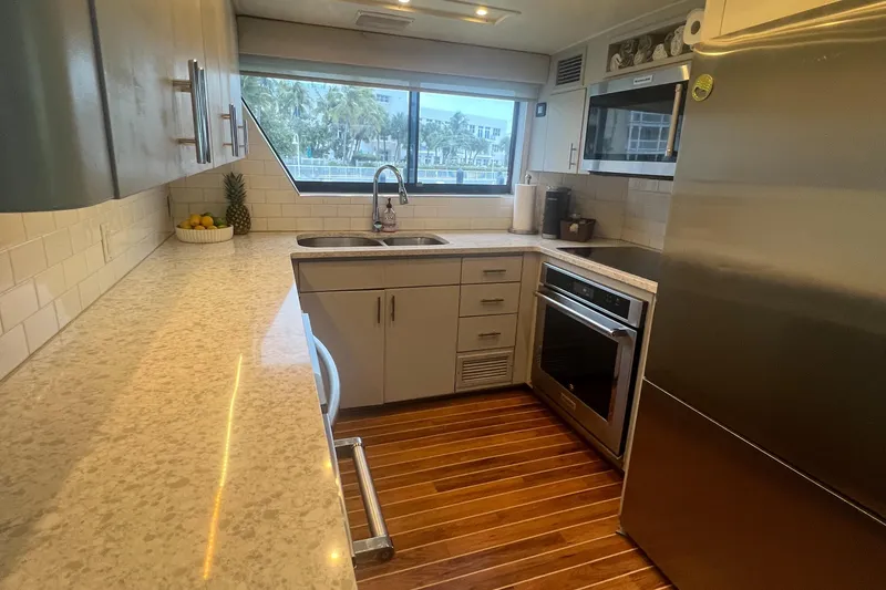Slide: The Image of Modern kitchen interior on 1990 Hatteras 70 Cockpit Motor Yacht with sleek countertops and appliances. - 20