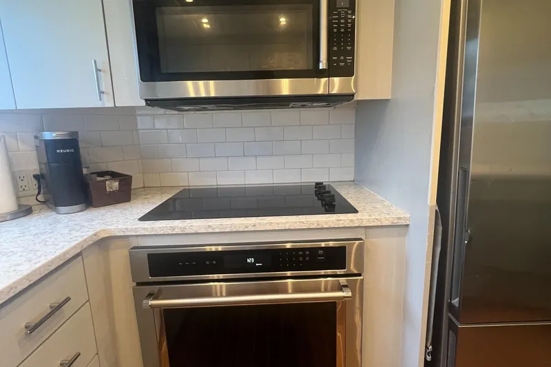 Slide: The Image of Modern kitchen with stainless steel appliances and white subway tile backsplash. - 24