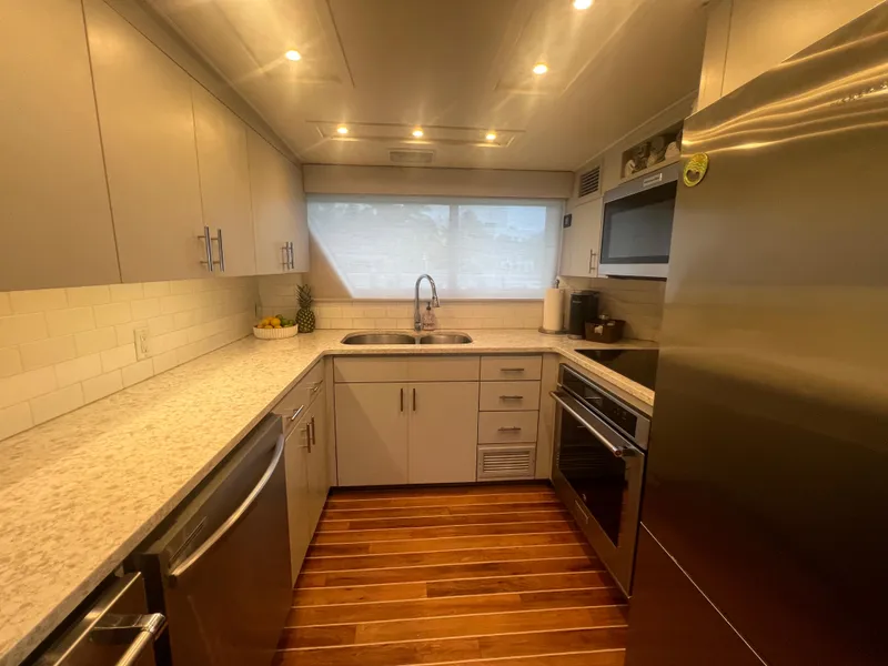 Slide: The Image of Modern kitchen interior on 1990 Hatteras 70 Cockpit Motor Yacht with stainless steel appliances. - 26