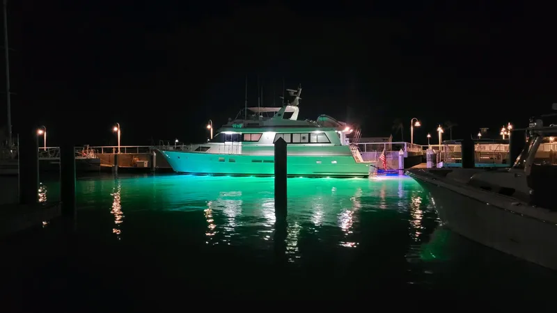 Slide: The Image of Hatteras 70 Cockpit Motor Yacht 1990 illuminated at night in marina. - 3