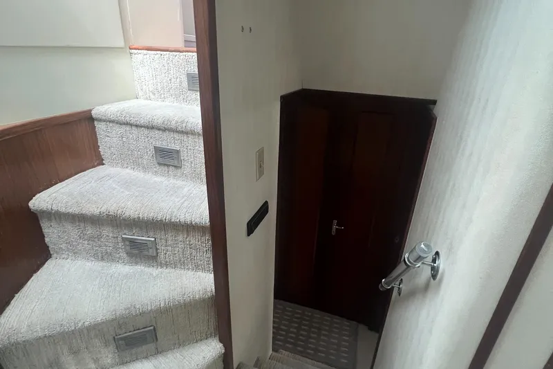 Slide: The Image of Interior stairs of 1990 Hatteras 70 Cockpit Motor Yacht, featuring carpeted steps and wooden accents. - 30