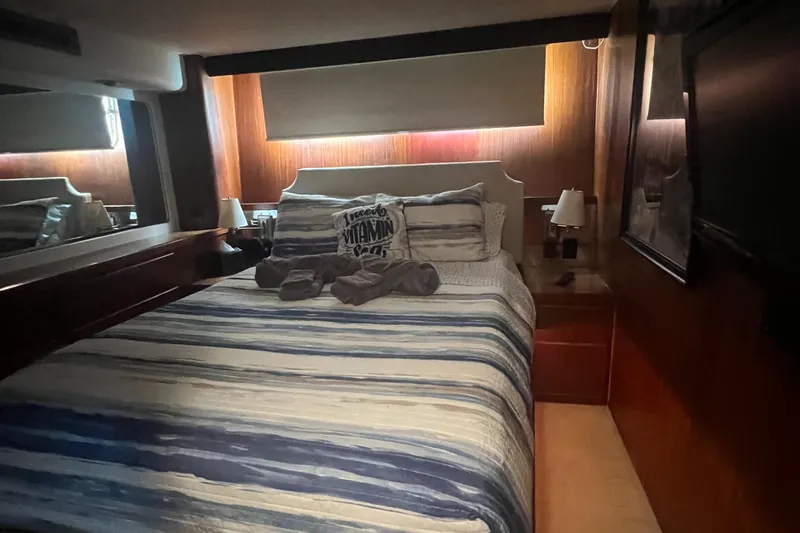 Slide: The Image of Cozy bedroom in 1990 Hatteras 70 Cockpit Motor Yacht with striped bedding. - 32