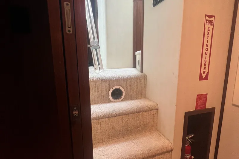 Slide: The Image of Staircase inside 1990 Hatteras 70 Cockpit Motor Yacht with fire extinguisher. - 37
