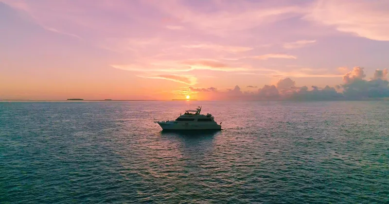 Slide: The Image of Hatteras 70 Cockpit Motor Yacht, 1990, cruising at sunset on open sea. - 4