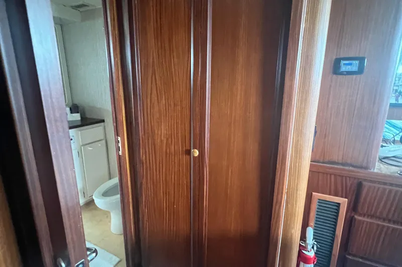 Slide: The Image of Interior of 1990 Hatteras 70 Cockpit Motor Yacht with wooden cabinetry and bathroom view. - 41