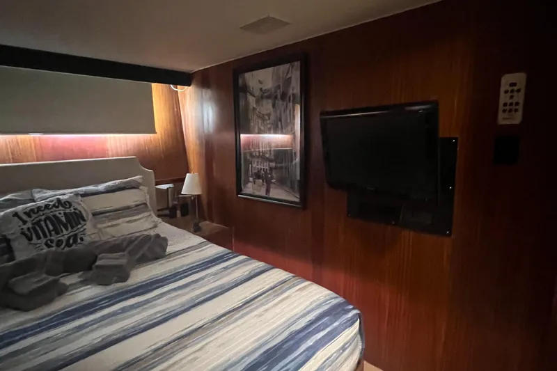Slide: The Image of Cozy bedroom in 1990 Hatteras 70 Cockpit Motor Yacht with TV and striped bedding. - 42