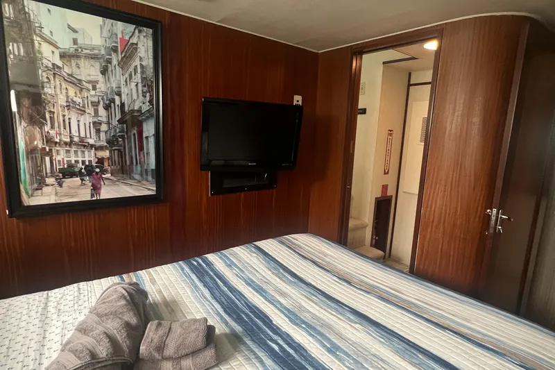 Slide: The Image of Interior of 1990 Hatteras 70 Cockpit Motor Yacht bedroom with TV and artwork. - 45