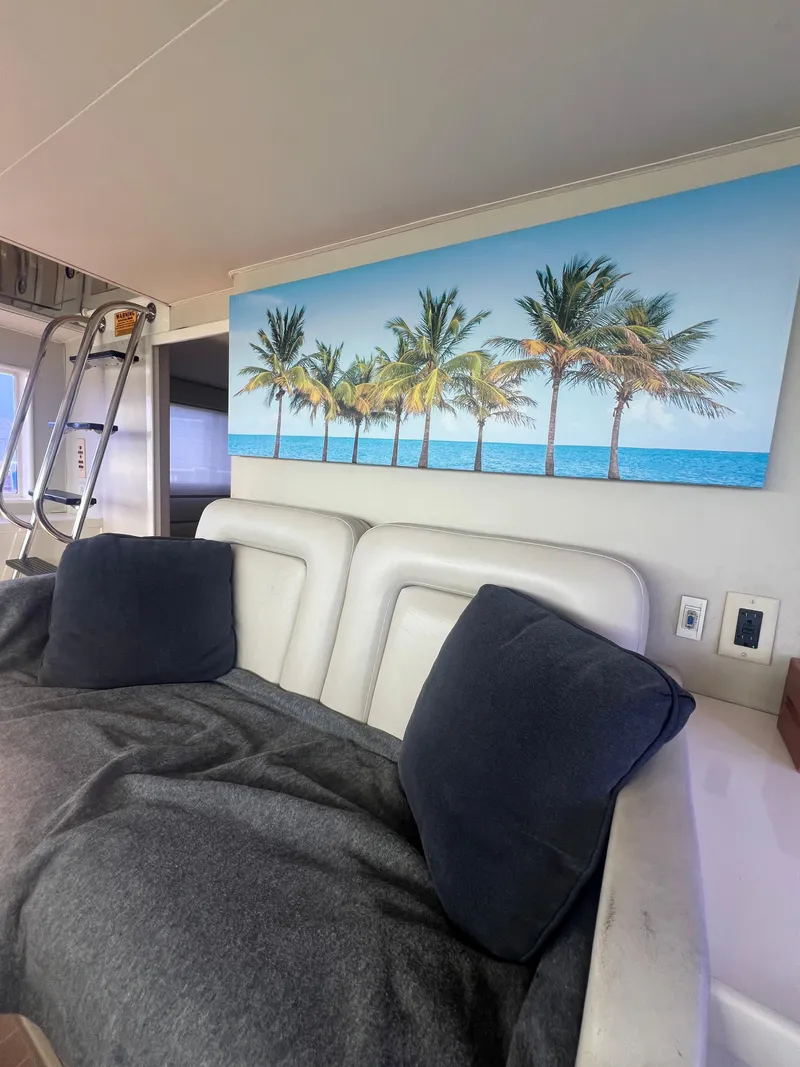 Slide: The Image of Interior of 1990 Hatteras 70 Yacht with palm tree artwork and cozy seating. - 49