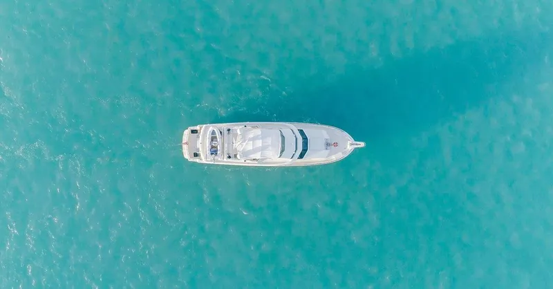 Slide: The Image of Aerial view of 1990 Hatteras 70 Cockpit Motor Yacht on turquoise water. - 6