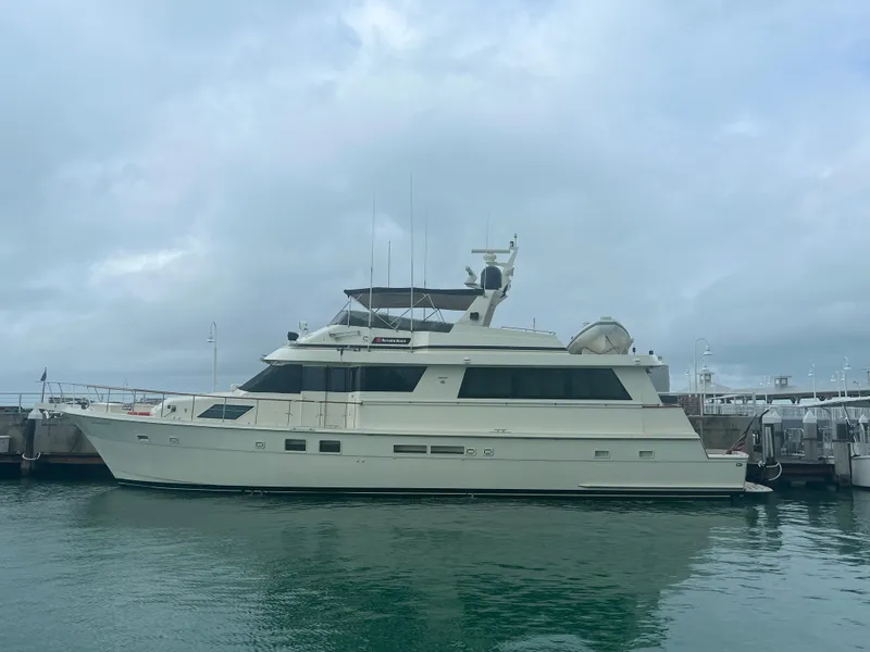 Slide: The Image of 1990 Hatteras 70 Cockpit Motor Yacht docked in a marina. - 7