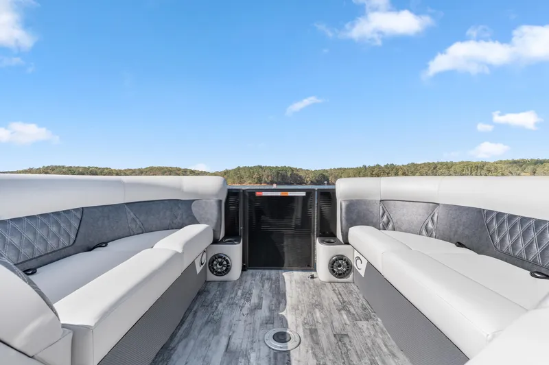 Slide: The Image of 2021 Crest Classic DLX 220 SLRC pontoon boat interior with gray seating and speakers. - 10