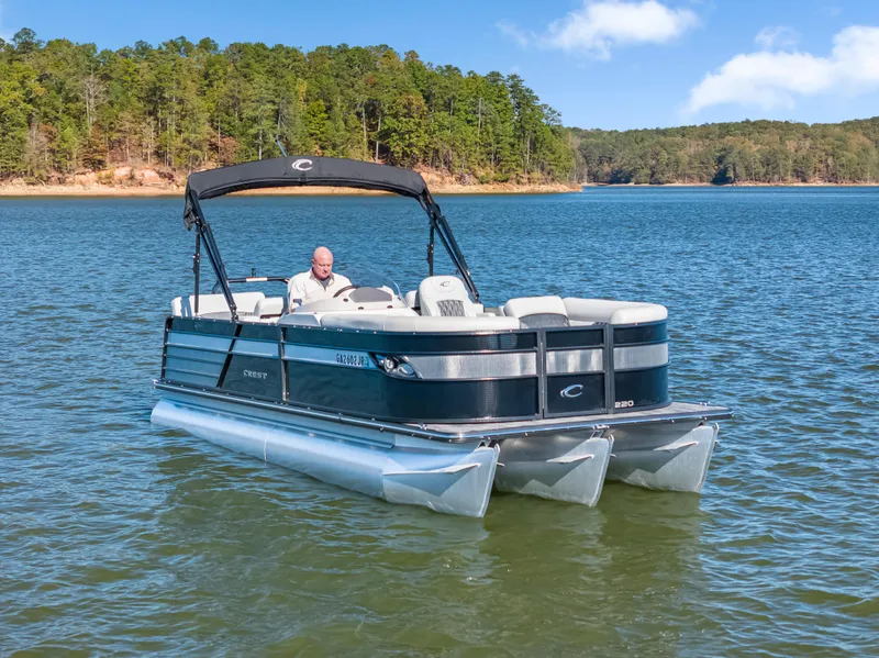 Slide: The Image of 2021 Crest Classic DLX 220 SLRC pontoon boat on a scenic lake. - 9