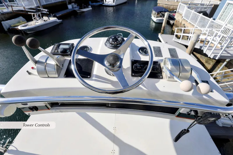 Slide: The Image of Tower controls of a 2000 Cabo 35 Express boat, featuring steering wheel and throttle levers. - 13