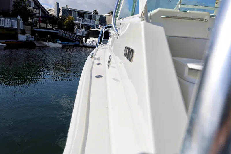 Slide: The Image of 2000 Cabo 35 Express boat docked in a marina, showcasing sleek design and waterfront homes. - 17