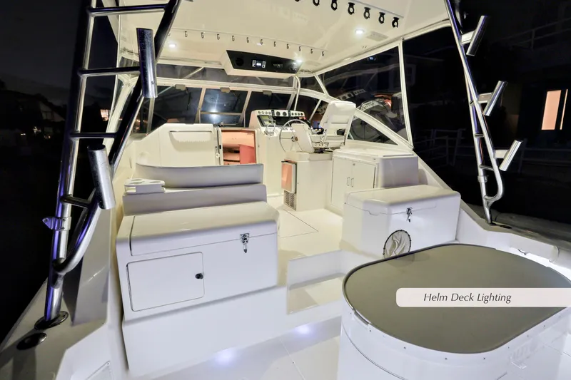 Slide: The Image of Cabo 35 Express 2000 model with illuminated helm deck and seating area at night. - 26