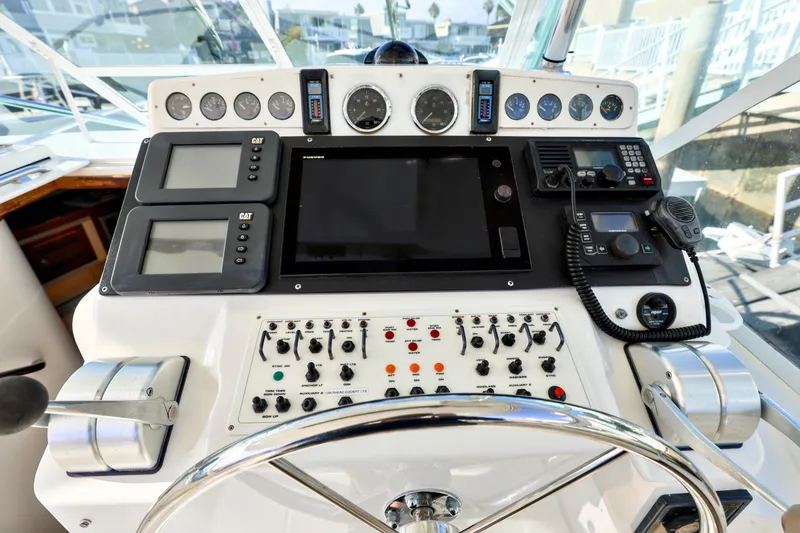 Slide: The Image of Control panel of a 2000 Cabo 35 Express boat with navigation instruments and steering wheel. - 4
