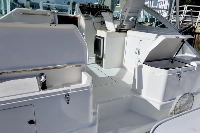 Slide: The Image of 2000 Cabo 35 Express boat interior with open storage compartments and control panel. - 8