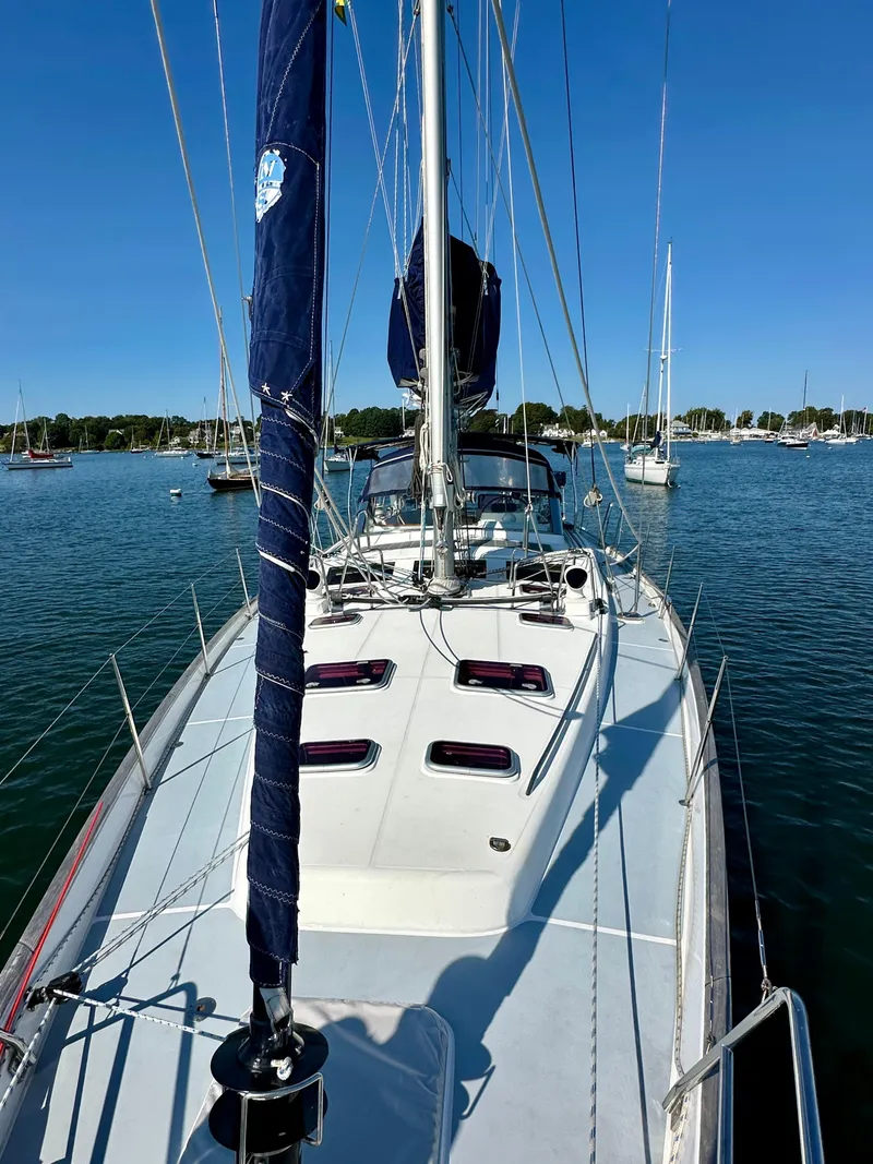 Slide: The Image of 2010 Beneteau 57 sailboat on calm water, clear sky, marina background. - 12