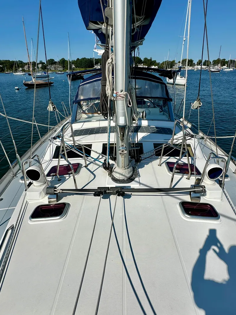 Slide: The Image of 2010 Beneteau 57 sailboat deck with masts, moored in a marina. - 13