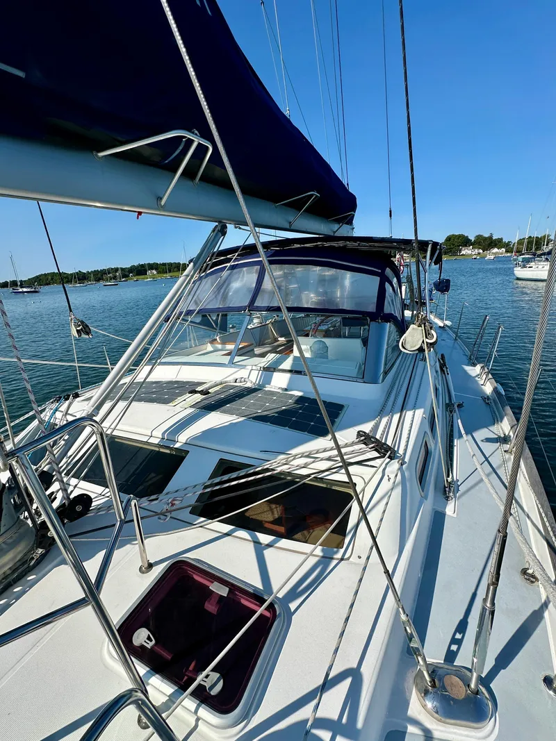 Slide: The Image of 2010 Beneteau 57 sailboat on calm water, showcasing deck and rigging. - 14