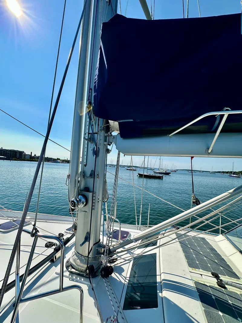 Slide: The Image of 2010 Beneteau 57 sailboat deck with mast, moored in sunny harbor. - 15