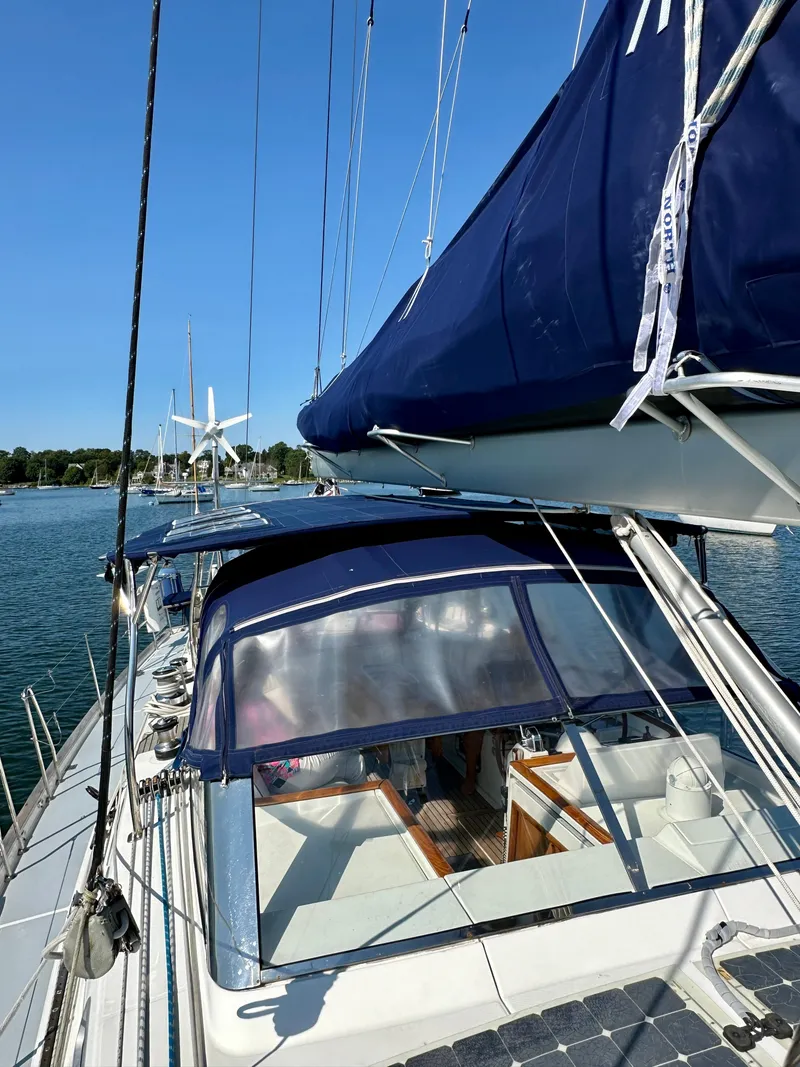 Slide: The Image of 2010 Beneteau 57 sailboat with blue sails docked in a serene marina. - 18