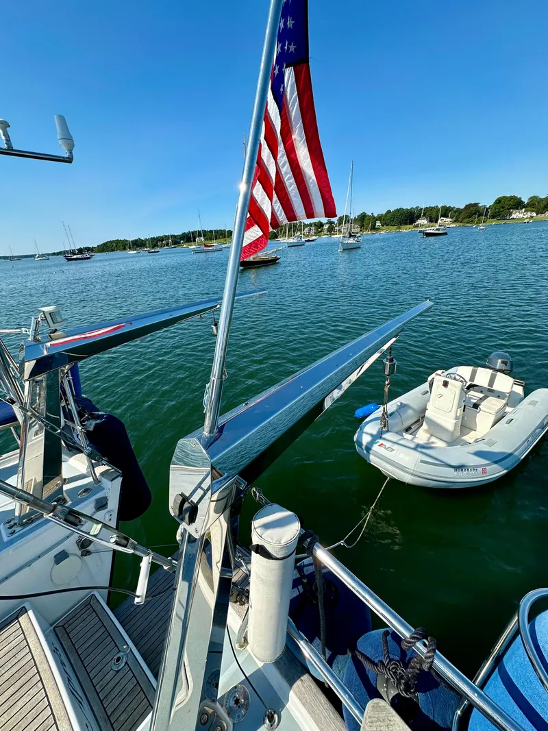 Slide: The Image of Beneteau 57 sailboat (2010) with American flag, docked near other boats on a sunny day. - 23
